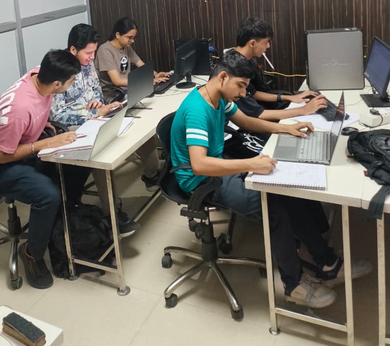 Learners coding and taking notes in class